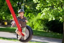 Хлопчик на гойдалці в парку — стокове фото