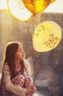 Chica sosteniendo nuevos globos víspera de años - foto de stock