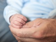 Мужчина, держащий младенца за руку — стоковое фото
