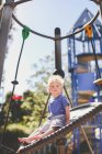 Мальчик на детской площадке сидит на качелях — стоковое фото