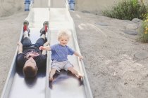 Two boys playing on slide — Stock Photo