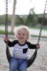 Smiling boy on swing — Stock Photo