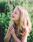 Sorrindo menina segurando um buttercup — Fotografia de Stock