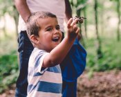 Niño sosteniendo conos de pino - foto de stock