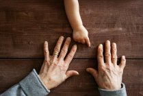Jungenhand zeigt auf Großmutters Hände — Stockfoto