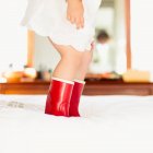 Девушка в красных сапогах на кровати — стоковое фото