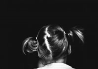 Girl with pigtails on black — Stock Photo