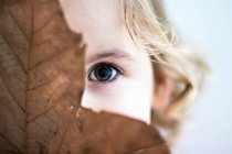 Girl hiding behind leaf — Stock Photo