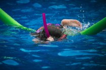 Menina nadando em uma piscina — Fotografia de Stock