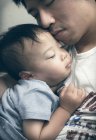 Boy sleeping in father lap — Stock Photo