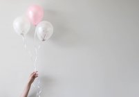 Mão segurando balões com confete — Fotografia de Stock
