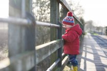 Мальчик стоит на мосту — стоковое фото
