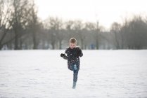 Garçon jouer dans la neige — Photo de stock