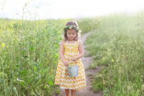 Дівчина тримає відро повне квітів — стокове фото