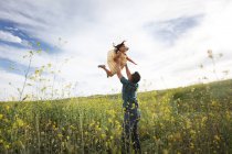 Vater hebt Tochter in die Luft — Stockfoto