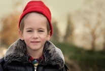 Усміхнений хлопчик у червоному капелюсі — стокове фото