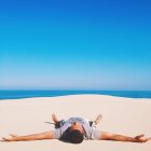 Uomo sdraiato sulla spiaggia — Foto stock