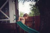 Мальчик на горке во дворе — стоковое фото
