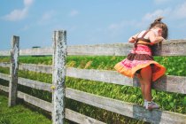 Girl standing on fence — Stock Photo