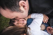 Отец, сын и дочь щекочут друг друга — стоковое фото