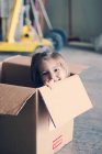 Girl sitting inside cardboard box — Stock Photo
