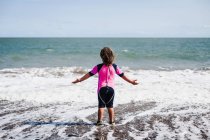 Rear view of girl in wetsuit — Stock Photo