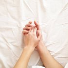 Casal deitado na cama de mãos dadas — Fotografia de Stock