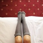 Женские ноги с носками на коленях — стоковое фото