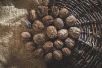 Walnuts in basket on textile — Stock Photo