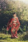 Frau im Kimono steht auf Feld — Stockfoto