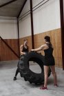 Atletas em treinamento de pneus em ginásio — Fotografia de Stock