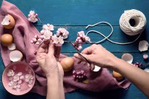 Женские руки, украшающие пасху — стоковое фото