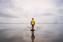 Мальчик, стоящий на скале у моря — стоковое фото