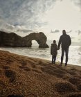 Отец и сын держатся за руки на пляже — стоковое фото