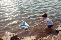 Garçon jouer avec jouet bateau — Photo de stock
