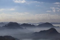 Foggy paysage de montagne au lever du soleil — Photo de stock