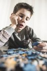 Хлопчик збирає головоломки — стокове фото