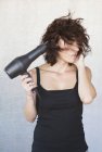 Frau föhnt Haare — Stockfoto