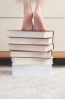 Menina de pé na pilha de livros — Fotografia de Stock