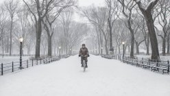 Woman cycling through snow in Central Park — Stock Photo