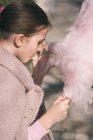 Menina comendo algodão doce — Fotografia de Stock