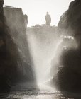 Чоловік стоїть на каменях біля океанського припливу басейну — стокове фото