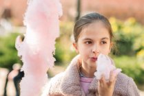 Дівчина їсть бавовняні цукерки — стокове фото