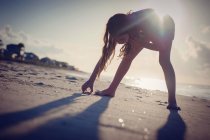 Девушка ищет ракушки на пляже — стоковое фото