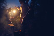 Человек держит фонарь во время похода — стоковое фото