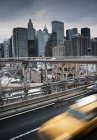 Taxi conduciendo a través de Brooklyn Bridge - foto de stock