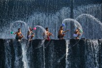 Пять детей, плескающих воду, плотина Тукад Унда, Бали, Индонезия — стоковое фото
