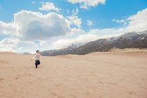 Boy running at great sand dunes national park — Stock Photo