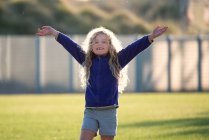 Девушка, стоящая с руками в воздухе — стоковое фото