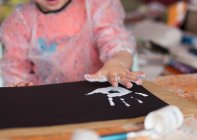 Мальчик делает отпечаток руки краской — стоковое фото